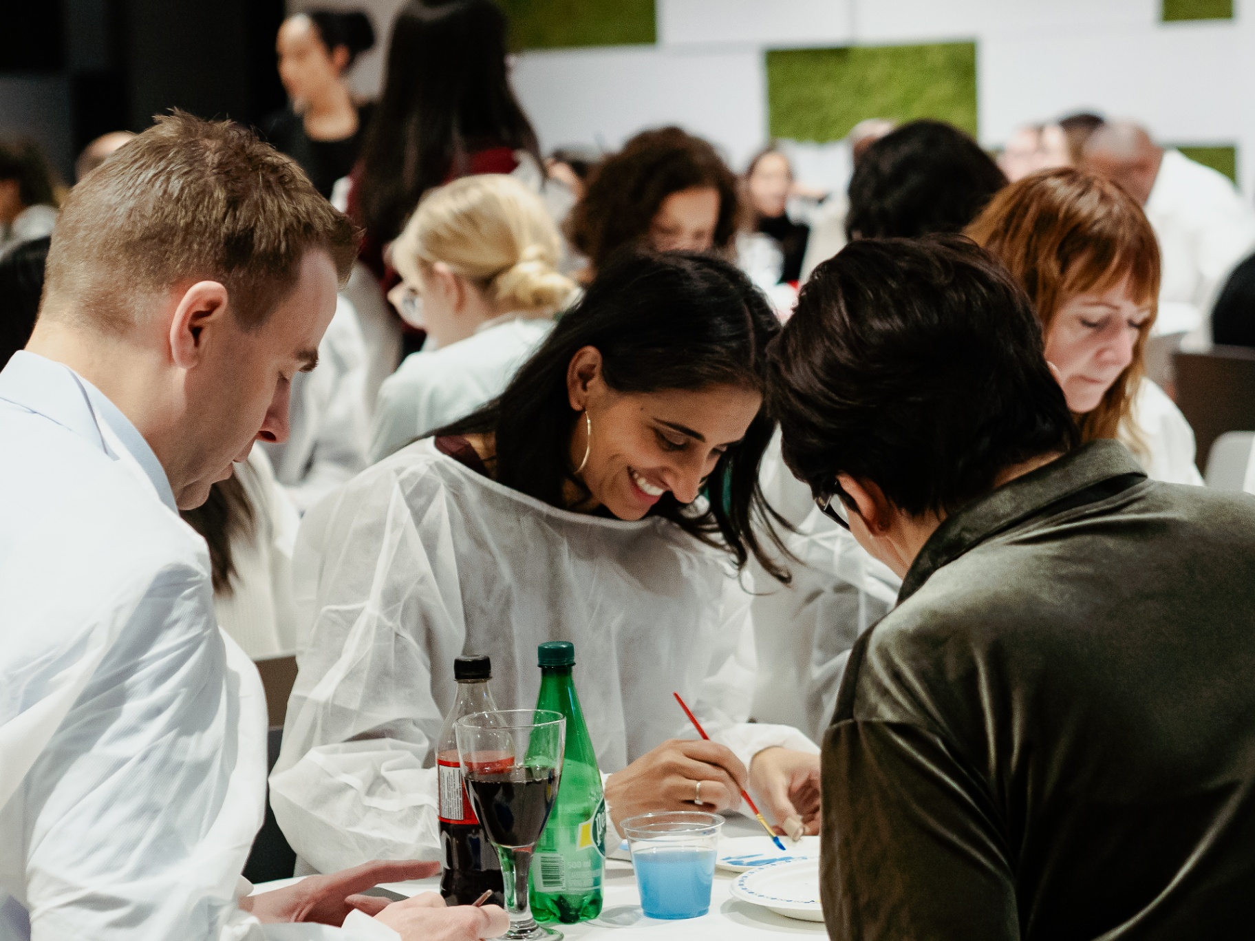 Colleagues collaborating around a painting table